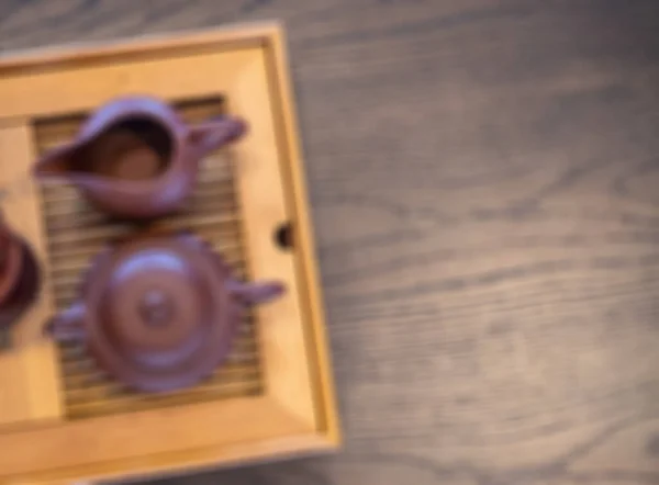 Japanese tea ceremony. Rustic tea pot on wooden table. Way of tea blurred photo background. Traditional tea drinking concept