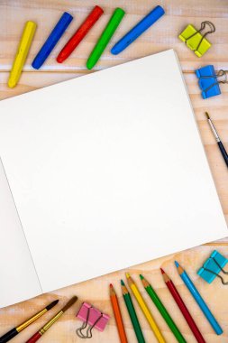 Ahşap masa üzerinde sanat aletleri olan açık çizim defterinin boş sayfası. Sanatsal masa manzaralı fotoğraf. Çizim ya da taslak modeli