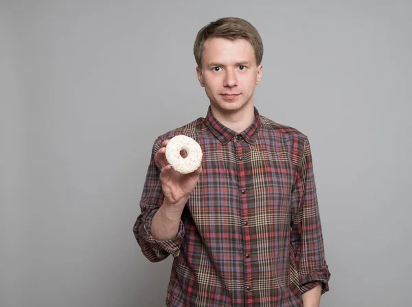 Молодой человек с пончиком — стоковое фото
