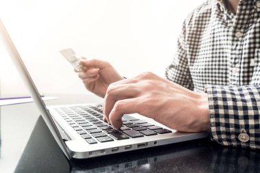 Plastik kart ve bir dizüstü bilgisayar ile el