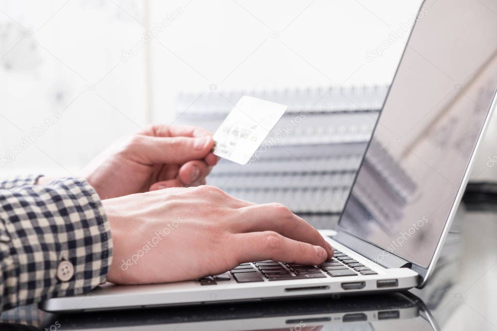 Hands with plastic card and laptop