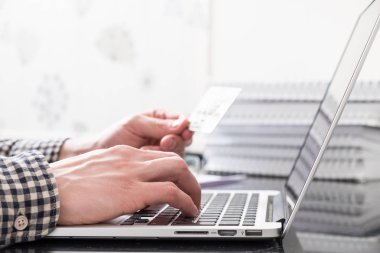 Plastik kart ve bir dizüstü bilgisayar ile el