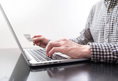 Plastik kart ve bir dizüstü bilgisayar ile el