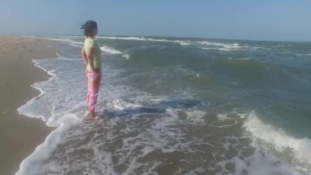 Сёрфер стоит на берегу моря — стоковое видео