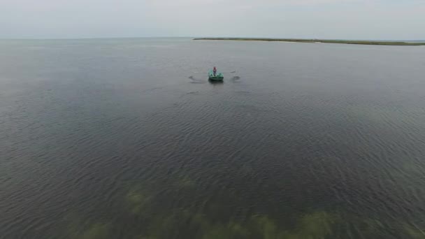 Mannen segling i den lilla roddbåt på det lugna havet — Stockvideo