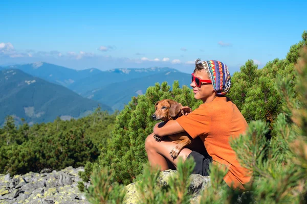 Genç uzun yürüyüşe çıkan kimse ile a küçük köpek
