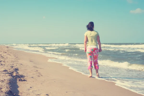Kobieta jest spaceru wzdłuż plaży — Zdjęcie stockowe