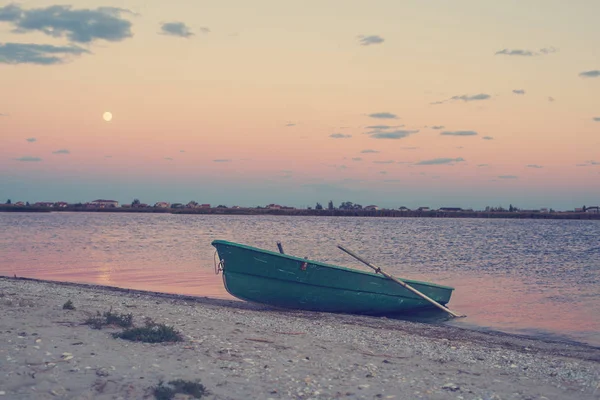 Старий човен на морському узбережжі під час висхідного місяця — стокове фото