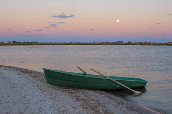 Liten roddbåt på havet kusten. Solnedgång — Stockfoto