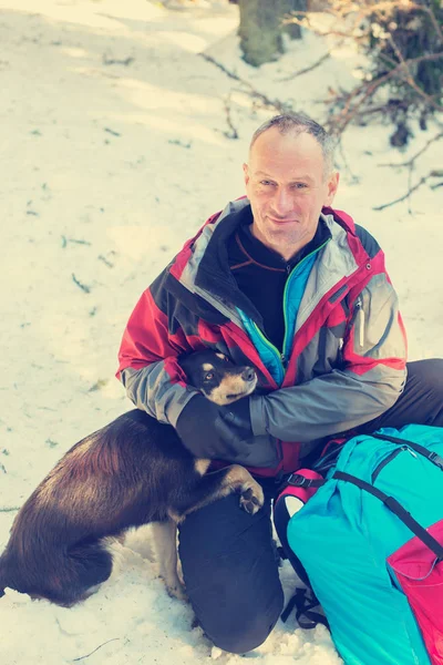 Улыбающийся турист обнимается с собакой — стоковое фото