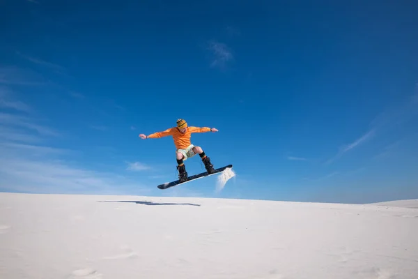 Snowboarder η πτήση πάνω από την άμμο αμμόλοφος. — Φωτογραφία Αρχείου