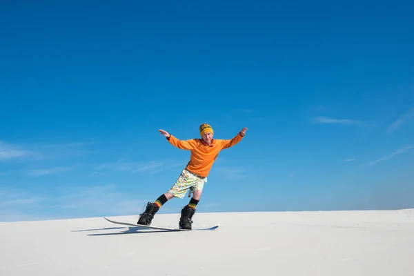 Ember lovaglás a snowboard, a homok dűne — Stock Fotó