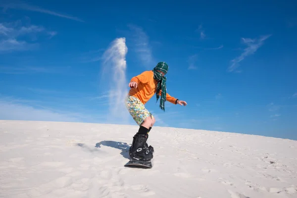 Snowboarder, portant une écharpe atterri après tour sur une pente de sable — Photo