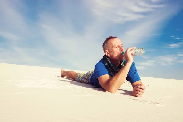 Turysta człowiek chętnie picie wody z małej plastikowej butelce — Zdjęcie stockowe