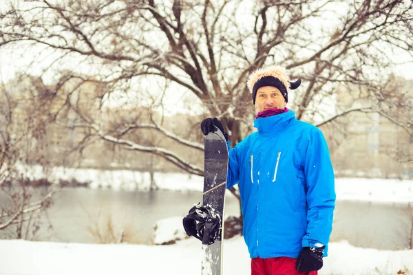 Homme au chapeau drôle avec snowboard — Photo