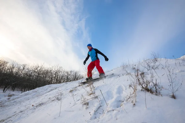 Snowboarder está montando na floresta de inverno. Ângulo largo — Fotografia de Stock