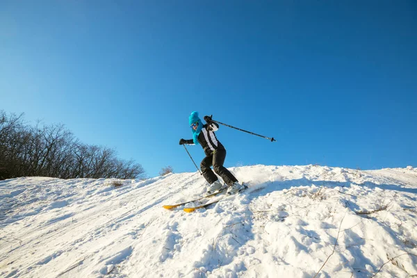 Kvinna skidåkare skidåkning nedför i skogen vinter — Stockfoto