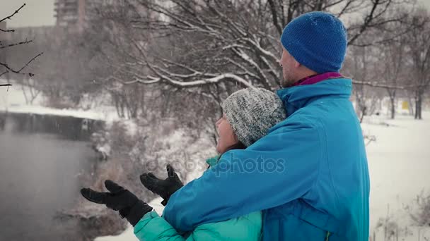 Пара обнимающихся в парке во время снегопада — стоковое видео