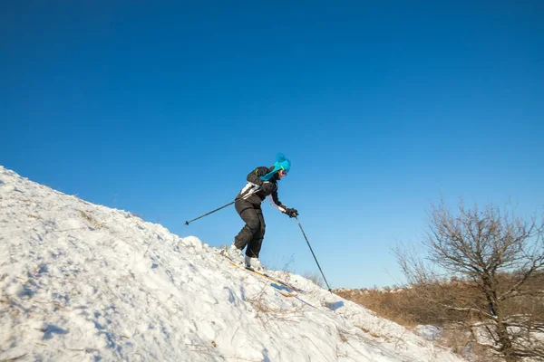Aktiv kvinna skidåkning nedför i vinter skog — Stockfoto