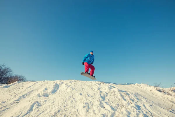 Snowboarder sautant sur fond de ciel bleu — Photo