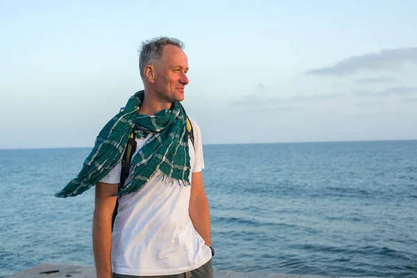 海の海岸に立って、スカーフ着用の男 — ストック写真