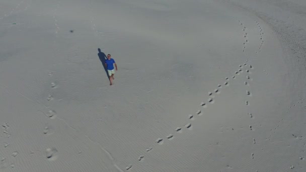 Человек идет по пустыне — стоковое видео