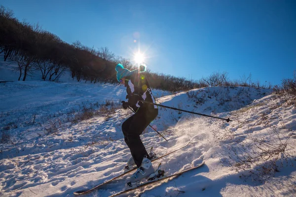 Sportig kvinna skidåkning nedförsbacke, gör en sväng på nära håll — Stockfoto
