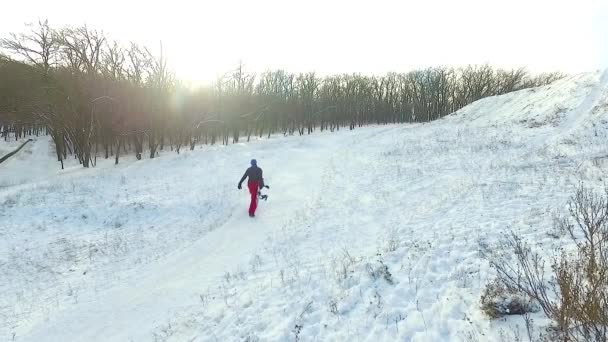 Сноубордист піднімається на пагорб — стокове відео