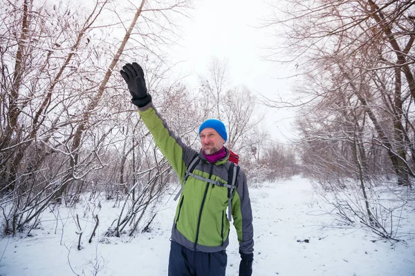 Un randonneur souriant et heureux agite la main, debout sur le sentier — Photo