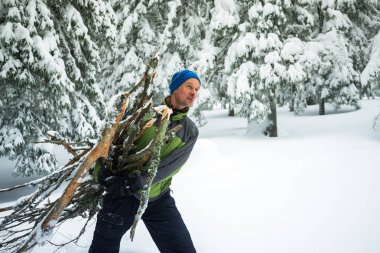 Yüz, bir kucak dolusu yakacak odun sürükler gülümseyen adam 