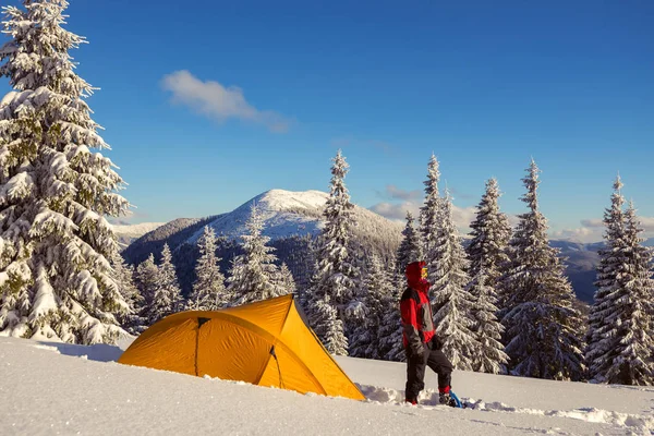 Stark man i snöskor och glasögon står bredvid ett gult tält — Stockfoto