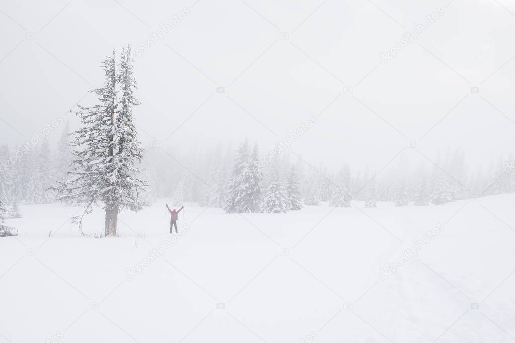 Traveler in the fog in the winter mountains