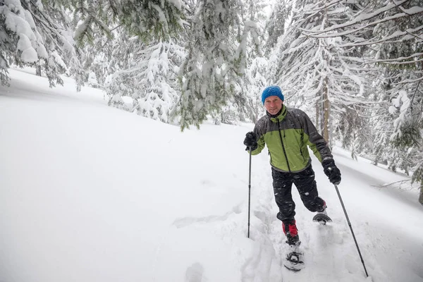 Freudiger Reisender läuft Schneeschuhwandern im Tiefschnee — Stockfoto