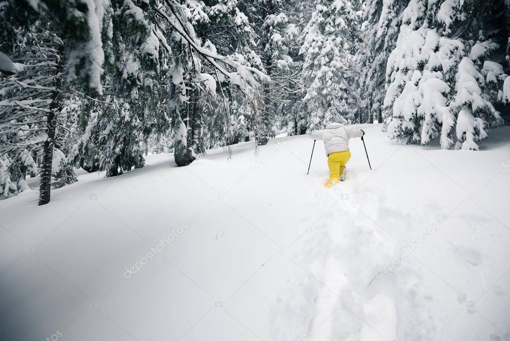Traveler goes on snowshoes in deep snow 