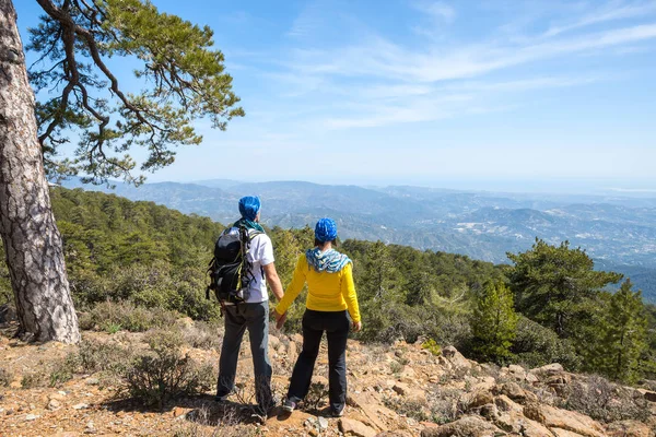 Un par de viajeros están de pie en la ladera rocosa — Foto de Stock