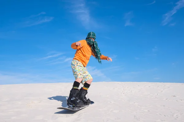 Homme snowboard parmi les dunes de sable - utilisation inhabituelle — Photo