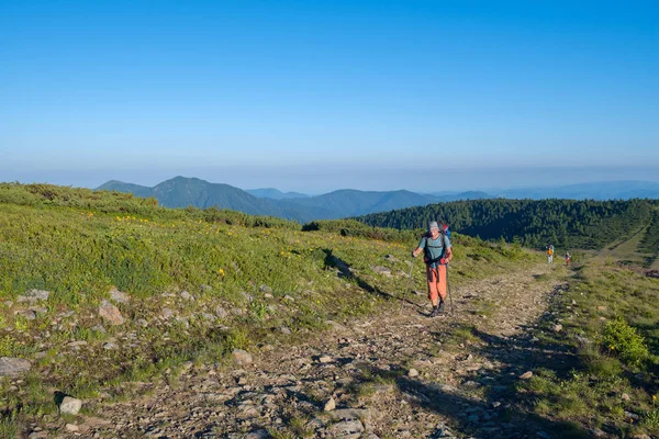 Reizigers - mannen en de jongen met rugzakken gaan langs een bergkam — Stockfoto