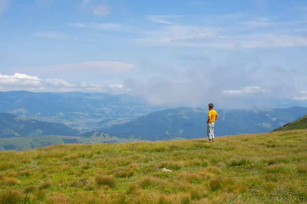 Reiziger is rusten op een alpine weide en het bewonderen van de panoram — Stockfoto