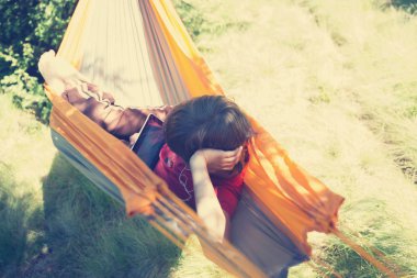 Çocuk hamakta sallanıyorum ve dijital tablet kullanma