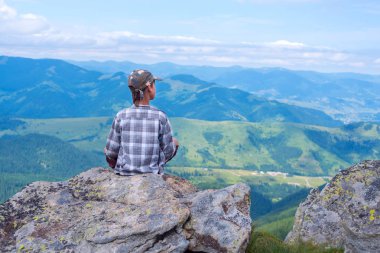 Çocuk uçurumun önünde dağlar oturur.
