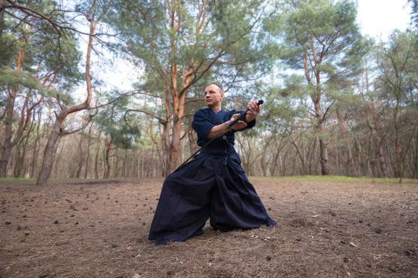 Koncentrerade man med ett japanskt svärd, katana öva Iaid — Stockfoto