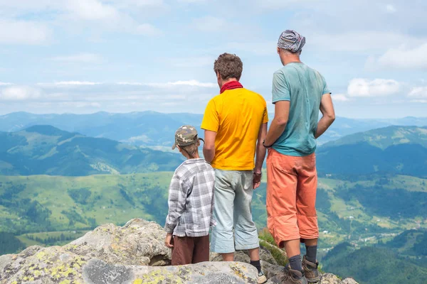 Amigos estão em uma rocha olhando para a paisagem da montanha — Fotografia de Stock