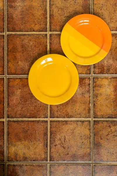 Due piatti multicolori in un angolo su uno sfondo marrone — Foto Stock
