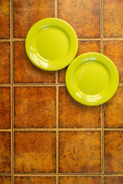 Due piatti verdi nell'angolo su sfondo marrone — Foto Stock