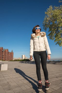 Parkta paten ve mutlu bir şekilde gülümseyerek neşeli kız silindir 