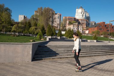 Parkta konsantre genç kadın paten paten 