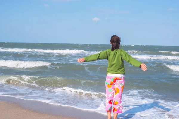 開けた腕を持つ喜びの女性は、喜んで、サーフィンに立っています — ストック写真