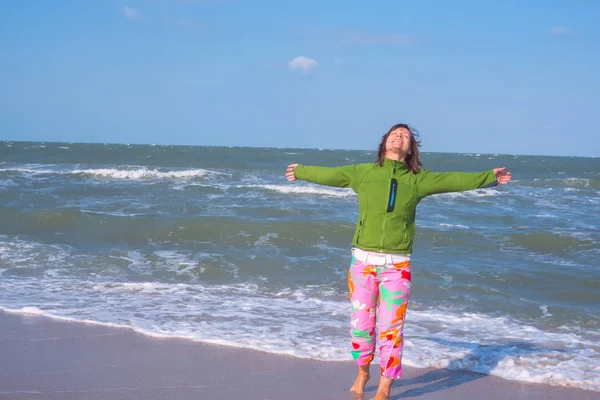 Sportowa kobieta stoi na plaży z otwartymi ramionami, — Zdjęcie stockowe