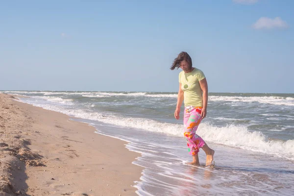 Szczęśliwa sportowa Kobieta, z latającymi włosami, spacerować wzdłuż surfowania — Zdjęcie stockowe