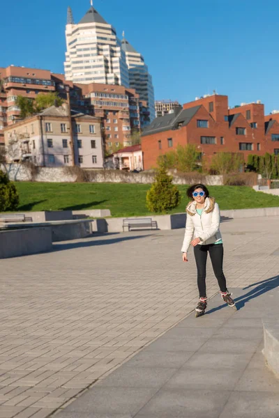 Fille heureuse dans un drôle de patinage à roulettes de lunettes de soleil dans le parc — Photo
